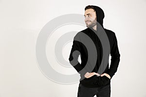 In profile attractive young man with a small beard in black clot