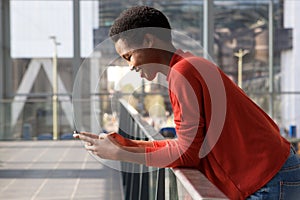 Profile of beautiful smiling african american woman looking at cellphone