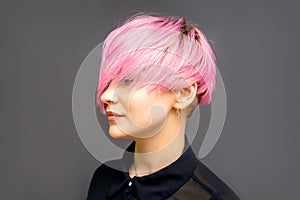 Profile of a beautiful young caucasian woman with short straight bob hairstyle dyed in pink color with closed eyes with