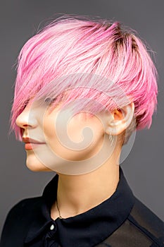 Profile of a beautiful young caucasian woman with short straight bob hairstyle dyed in pink color with closed eyes with