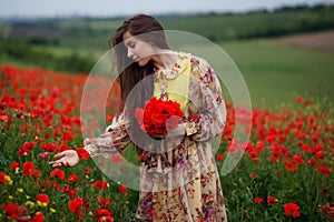 Profile of a beautiful young woman, long hair, standing in the red poppy flower field, beautiful landscape background