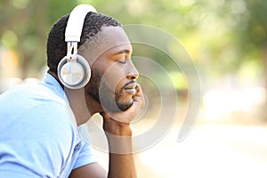 Profile of black man listening to music in a park