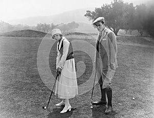 Profile of a couple playing golf in a golf course