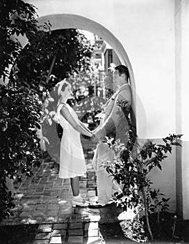 Profile of a couple romancing in an archway