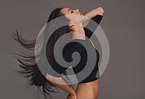 Profile, dancer and woman with confidence, movement and mockup space with girl on a grey studio background. Person