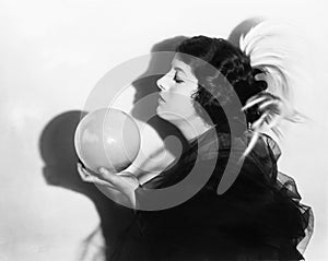 Profile of dramatic woman holding sphere