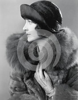 Profile of an elegant woman in a fur coat and satin hat