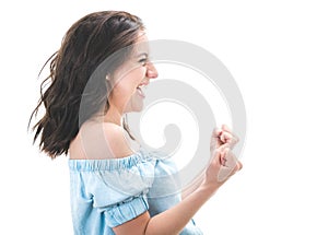 Profile of excited young woman with closed eyes and clenched fists, isolated on white background. Yes concept. Good news. Pretty