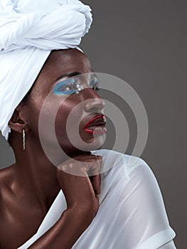 Profile, face and black woman with makeup, wrap or confidence in studio on grey background. Beauty glow, fashion or