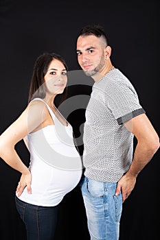 Profile face to face couple pregnant woman with man under black background
