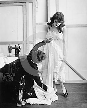 Profile of a female tailor taking measurement of a young woman in a bridal shop