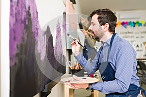 Profile of a handsome man taking a painting class for adults