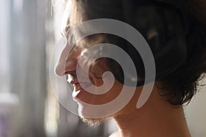 Profile of a happy and smiling young adult against window light