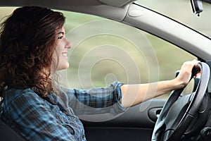 Profile of a happy woman driving a car