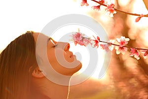 Profile of a woman smelling flowers in spring at sunset