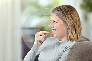 Profile of a happy woman taking a vitamin pill photo