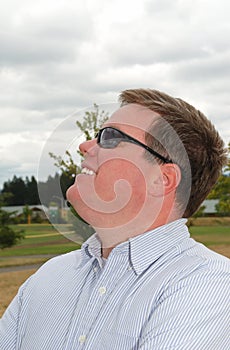 Profile of a happy young man in sunglasses.