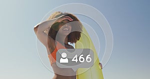 Profile icon with increasing numbers against woman with surfboard looking at a distance