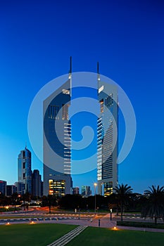 A profile of the iconic Emirates Towers in Dubai, UAE at dusk