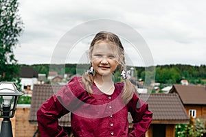 Profile of a little girl in a beard dress who is standing on a balkon, breathing fresh air.