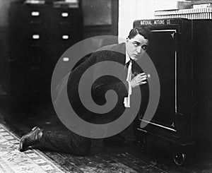 Profile of a man opening the door of a safe