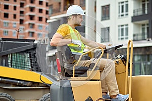 Profile of man sitting at wheel of excavator