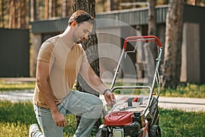 Profile of man turning on grass-cutter outdoors
