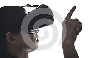 Profile of a man in virtual reality glasses showing by finger