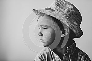 profile of a pensive cute child in a straw hat
