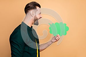 Profile photo of attractive funny guy holding green paper mind cloud screaming expressing own thoughts chatterbox wear