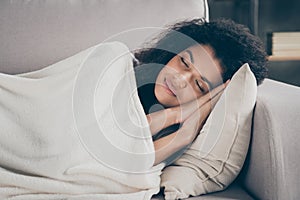 Profile photo of beautiful dark skin wavy lady holding hands under head eyes closed having daydream lying comfy couch