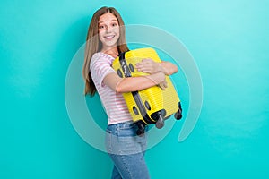 Profile photo of cheerful nice girl toothy smile arms hold suitcase isolated on teal color background