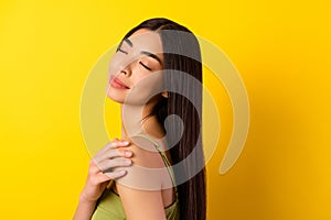 Profile photo of gorgeous positive indonesian girl closed eyes arm touch shoulder isolated on yellow color background