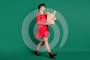 Profile photo of housewife lady paper bag food look empty space go wear hat red dress boots isolated green color