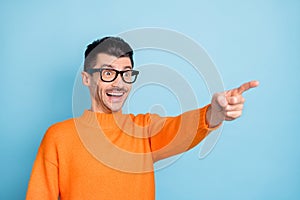 Profile photo of impressed guy open mouth smile look interested direct finger empty space isolated on blue color