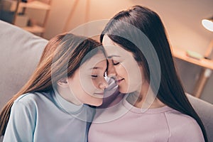 Profile photo of optimistic brunette red hairdo mom daughter hug sit on sofa wear sweater at home