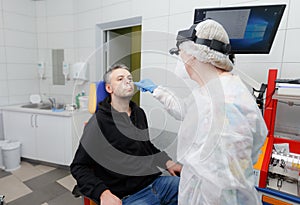 Profile photo of an otolaryngologist examining a patient`s nose.