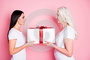 Profile photo of pretty old mother young daughter two ladies giving each other large gift box present affection feelings