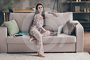 Profile photo of pretty optimistic girl sit write laptop wear spectacles pijama at home on sofa photo