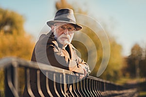 Profile photo of retired old white hair grandparent man street central park walk lean metal fence bridge near river