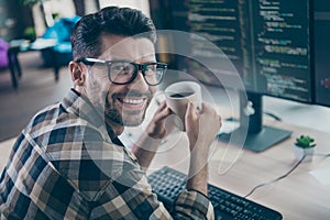 Profile photo of smart positive hacker guy arms hold fresh morning coffee toothy smile operating server open space