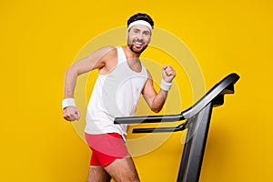 Profile photo of sportive energetic positive person enjoy running treadmill isolated on yellow color background