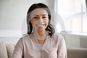 Headshot portrait of smiling biracial woman posing at home