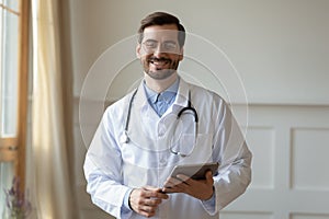 Headshot portrait of smiling male doctor with tablet photo