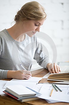 Profile portait of girl performing a written task in copybook