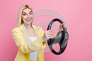 Profile portrait of astonished positive girl toothy smile arms hold wheel isolated on pink color background