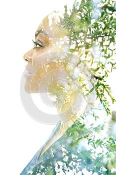 A profile portrait of an attractive woman combined with foliage. Double exposure.