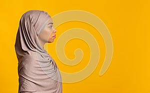 Profile portrait of black muslim woman in hijab over yellow background photo