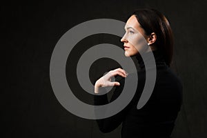 Profile portrait of a brunette woman on dark background