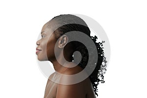 Profile portrait of elegant African woman with curly dark hair, well-kept skin posing isolated on white studio